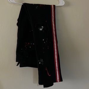 Black jeans with red strips and red paint